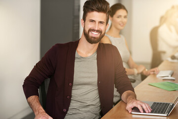Aufkleber - It always seems impossible until its done. Portrait of a young designer sitting in an office with his colleague blurred in the background.