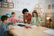 © Drazen - Black female teacher having art class with group of kids at preschool.