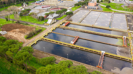Wall Mural - Aerial view of the tanks of a sewage and water treatment plant enabling the discharge and re-use of waste water. It's a sustainable water recycling with treatment plant.