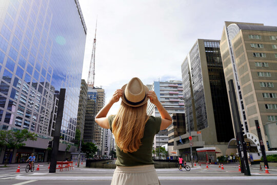beautiful girl arrives in the big city of sao paulo. young woman with hat on paulista avenue in sao 