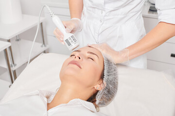 Beautician makes cryotherapy for rejuvenation woman face, anti aging cosmetic procedure with in beauty spa salon. Cosmetologist makes cryo therapy lifting with for skin rejuvenation and smoothing