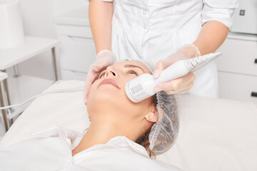 Beautician makes cryotherapy for rejuvenation woman face, anti aging cosmetic procedure with in beauty spa salon. Cosmetologist makes cryo therapy lifting with for skin rejuvenation and smoothing