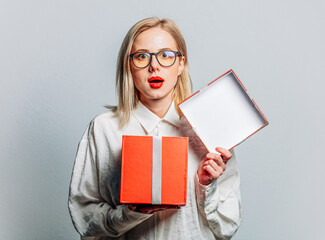 Wall Mural - Portrait of beautiful blonde in white shirt with gift box on white background