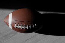 American Football Leather Ball On Grey Wooden Background. Top View. Game Equipment Horizontal Sport Theme Poster, Greeting Cards, Headers, Website And App