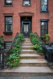 a brownstone building with a lot of blooming flowers on an iconic street in Manhattan, New York City