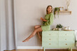 © mary_markevich - young stylish smiling woman in green summer dress in modern interior apartment home