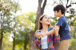 © DG PhotoStock - Asian woman and boy playing and walking around the park together with beautiful bokeh and lighting background copyspace. Little cute boy hogging his mother from back and kissing.