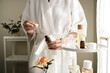 The woman wearing a bathrobe drop the serum on her skin. Skincare and spa concept. the beauty care and wellness lifestyle.