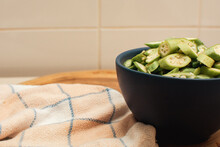 Sliced Okra Salad In Blue Bowl On Wooden Board