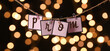 Rope with clips and paper word PROM against blurred lights