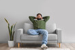 © Pixel-Shot - Handsome bearded man resting on grey sofa near light wall
