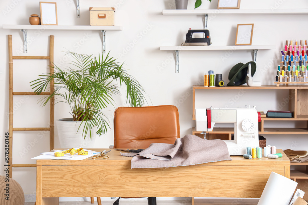 Tailor's workplace with sewing machine in interior of modern atelier