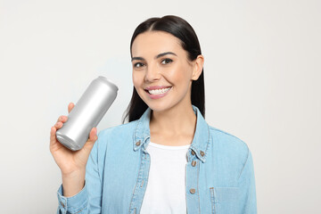 Sticker - Beautiful happy woman holding beverage can on light grey background