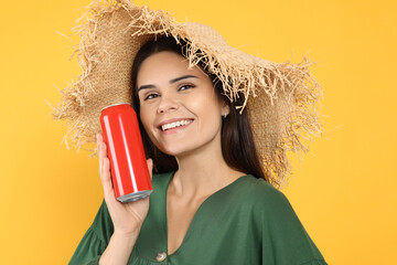 Poster - Beautiful happy woman holding red beverage can on yellow background