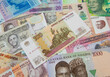 A collection of African currencies with a one hundred ruble bank note sitting on top