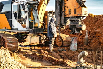 Hydraulic drilling machine at the construction site. Pile field. Modern drilling rig. The device of piles on the background of the blue sky. Work drilling rig when driving bored piles.