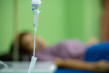 woman doctor monitor adjust the drip rate feed of saline dripping intravenous infusion to patient on
