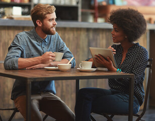 Wall Mural - Should we order something to eat. a young couple using a digital tablet together on a coffee date.