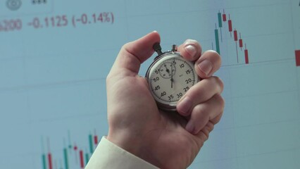 Wall Mural - Stopwatch in a hand against background of chart