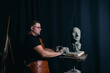 © primipil - Man sculptor creates sculpt bust clay human woman sculpture. Statue craft creation workshop.