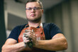© primipil - Man sculptor dressed leather apron with clay in hands. Statue craft creation workshop.