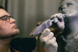 © primipil - Man sculptor creates sculpt bust human woman sculpture with hammer. Statue craft creation workshop.