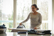 © AUFORT Jérome - mixed race woman ironing at home