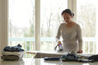 © AUFORT Jérome - mixed race woman ironing at home