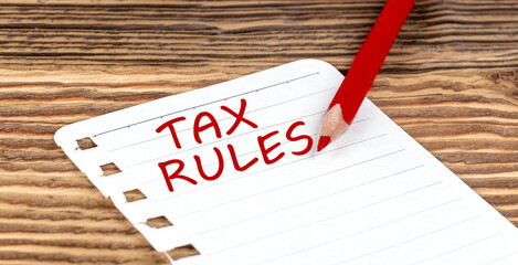 Poster - Word TAX RULES on a paper with ped pencil on wooden background