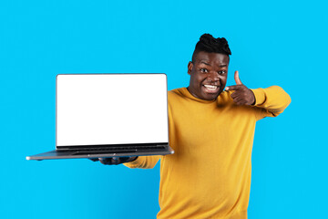 Wall Mural - Online Offer. Excited Black Man Pointing At Laptop With Blank White Screen