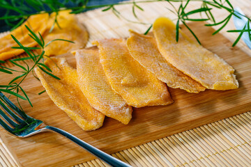 Kitchen table with dried mango on board