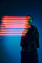 Half-length portrait of young stylish woman posing over dark blue background with neon mixed light lines. Concept of contemporary art, fashion, cyberpunk, futurism