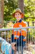 © Austockphoto - Happy teenage boy in high vis workwear standing in pool yard