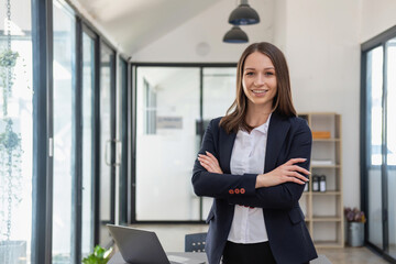 a stylish white businesswoman in a black suit standing inside the office in hands with a mobile phon