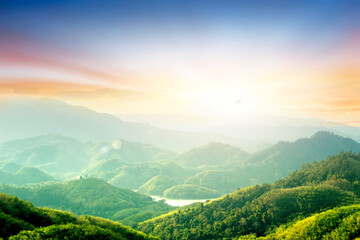 Wall Mural - forest on the mountain light fall on clearing on mountains at sunset sky background