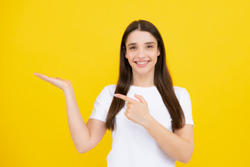 Woman point at copy space, showing copyspace pointing. Promo, girl showing advertisement content gesture, pointing with hand recommend product. Isolated background.