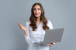 © Olena - Blogging chatting woman. Beautiful smiling business woman over grey background using laptop computer.