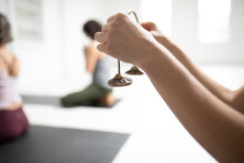 Woman Holding Tingsha Cymbals In Yoga Class