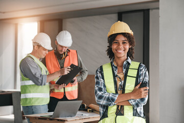 Wall Mural - Leadership Concept by Female Engineers : Portrait of a happy female engineer in front of a group of male construction workers : Effective teamwork