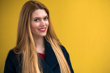 Wall Mural - Close up portrait of a young beautiful blonde model, isolated on yellow background