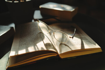 a close up shot of reading glasses on book