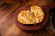 Homemade grilled chicken breast, flattened and seasoned on rustic wooden table. Closeup image.