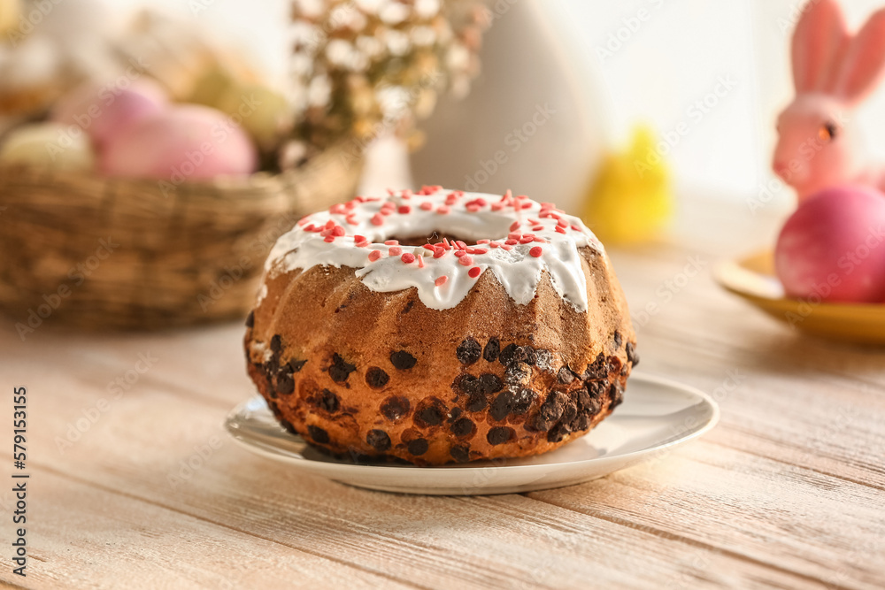 Plate with tasty Easter cake on white wooden table