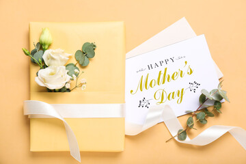 Wall Mural - Greeting card with text HAPPY MOTHER'S DAY, gift and beautiful flowers on beige background