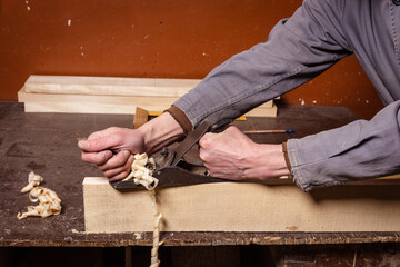 Wall Mural - A carpenter works in a workshop with a saw, planer and various tools