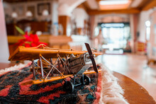 Closeup of wooden figurine of propeller airplane with textile decorated on table at alpine hotel room