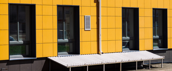 facade of store building with big windows close-up. industrial building with drain and basement. wal