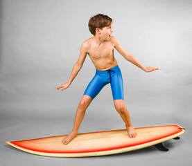 Wall Mural - Young boy pretending to ride on a surfboard