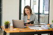 © Thitisak - Young Asian businesswoman holding notebook about business, spending money