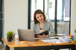© Thitisak - Young Asian businesswoman holding notebook about business, spending money